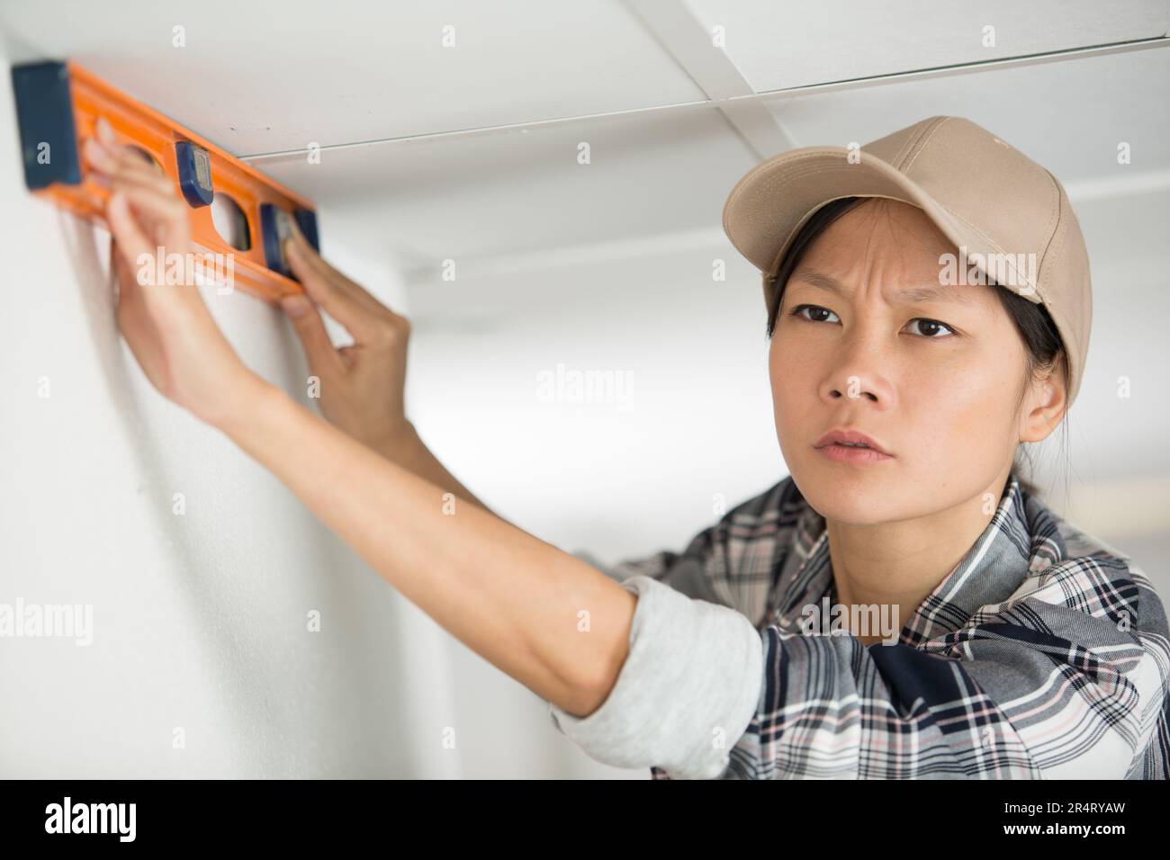 female asian builder using spirit level Stock Photo
