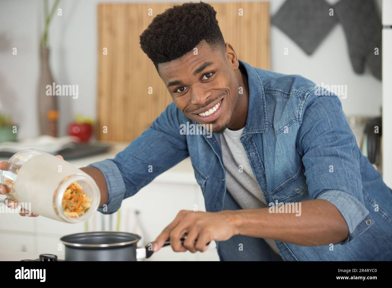 cropped shot of man with apron cooking pasta Stock Photo