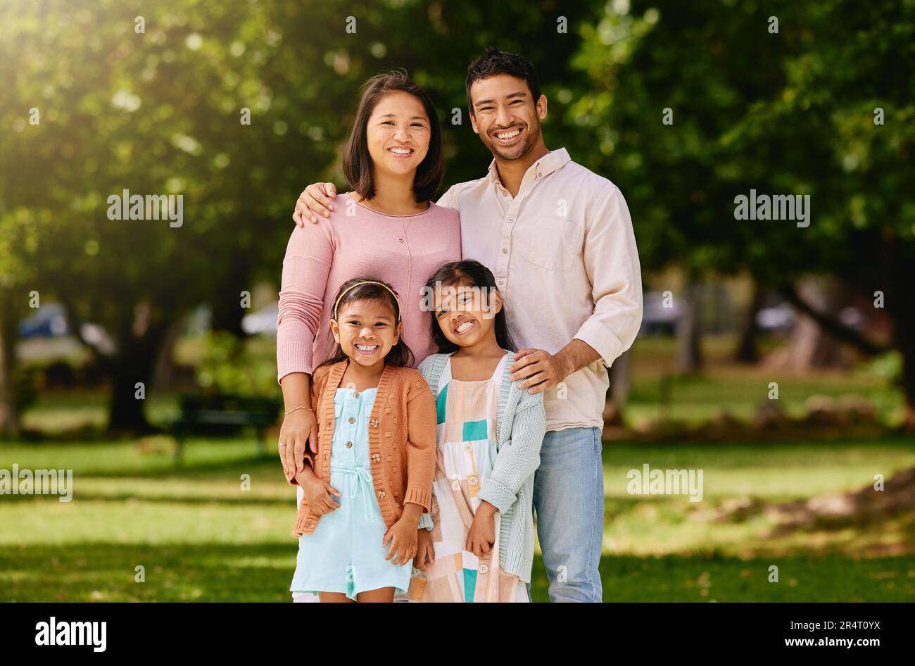 Portrait of happy family, parents and kids smile together in trees ...