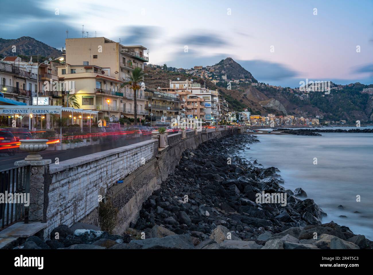 View of Taormina and Giardini Naxos promenade viewed from Giardini Naxos at dusk, Sicily, Mediterranean, Italy, Europe Stock Photo