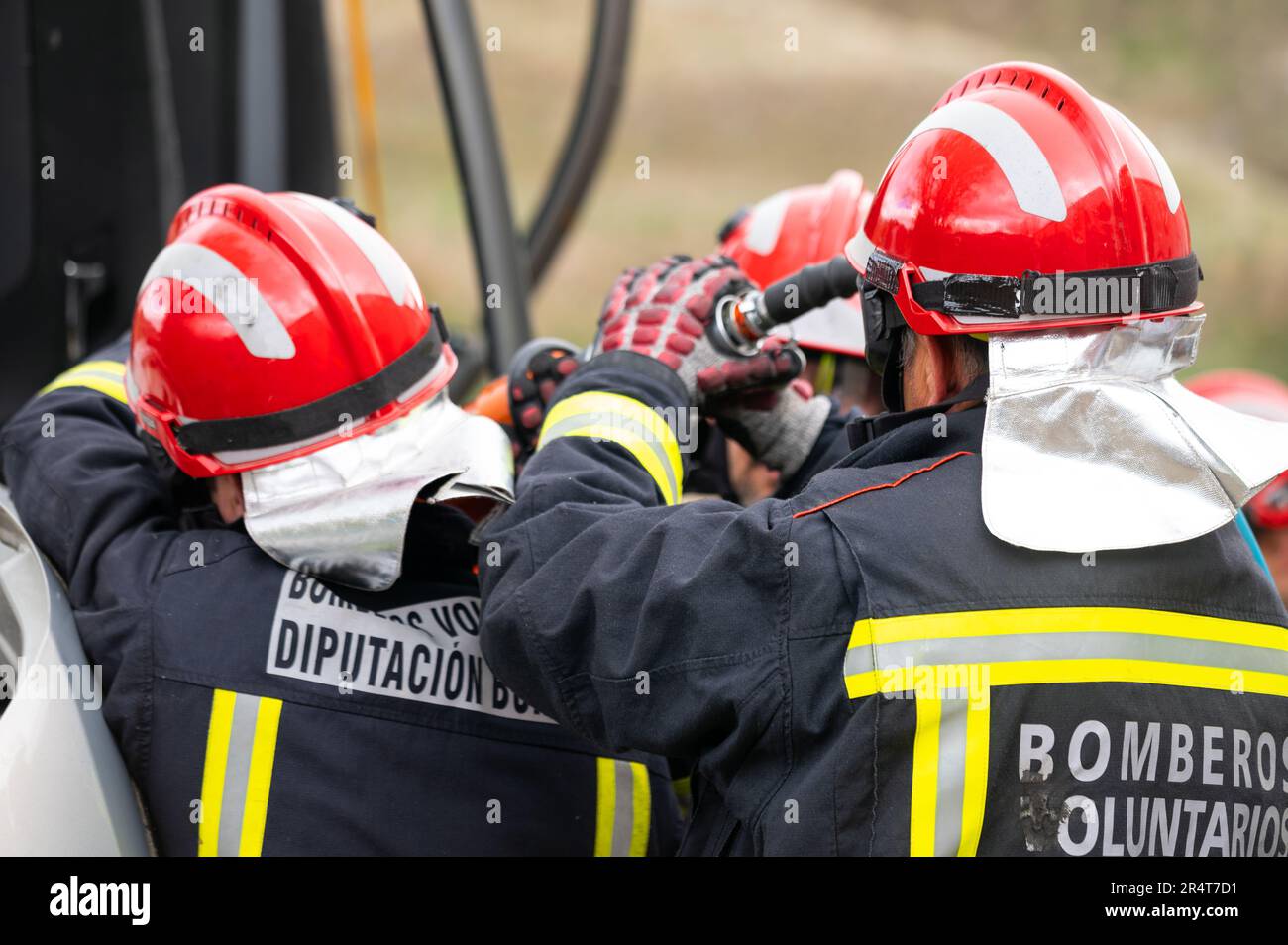 Firefighters using hydraulic tools during a rescue operation training. Rescuers unlock the passenger in car after accident. High quality photography. Stock Photo