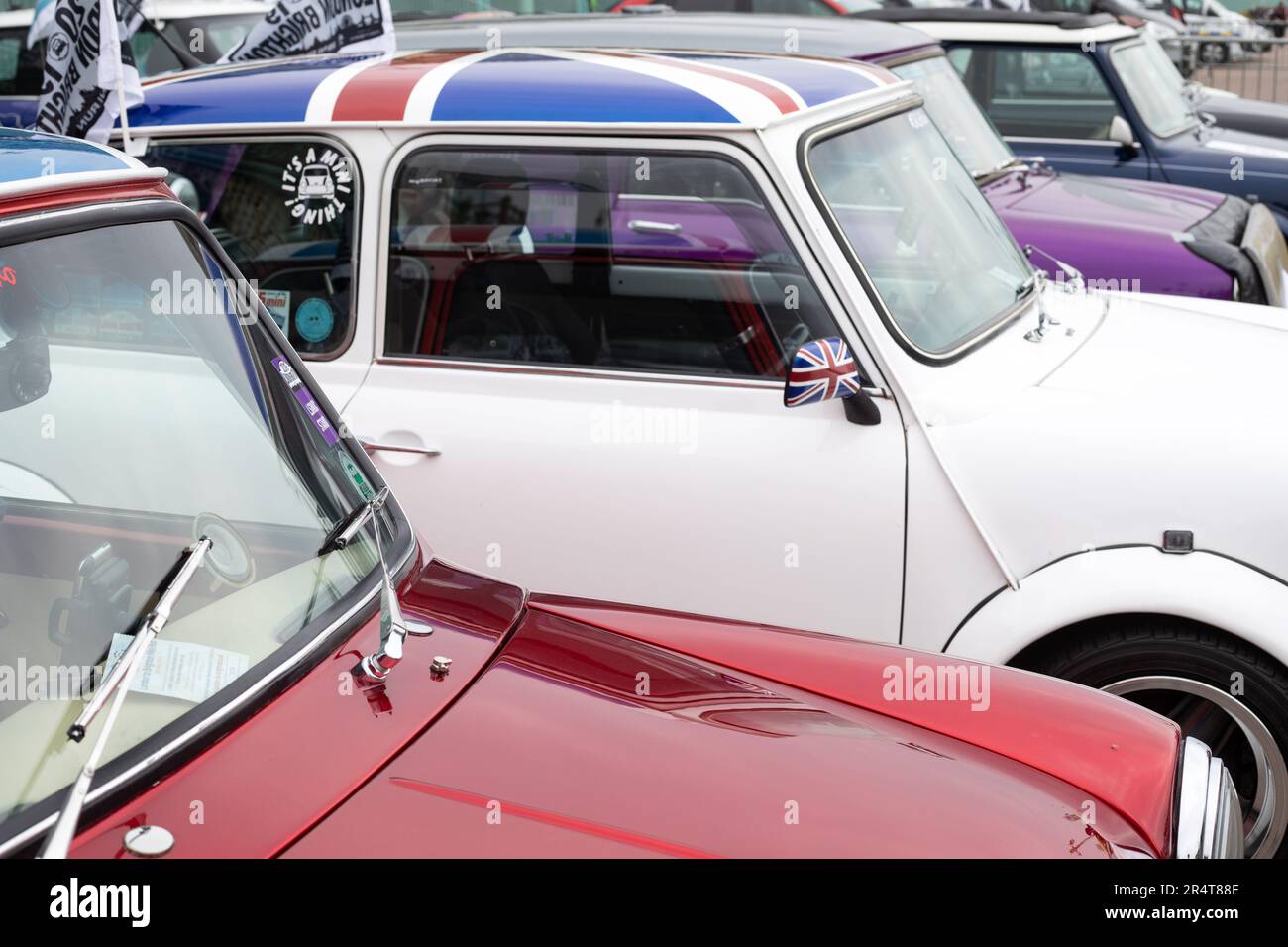 Brighton, UK - May 19 2019:  A row of retro Mini cars taking part in the London Brighton Mini Run 2019. The colours are red, white and purple. Stock Photo