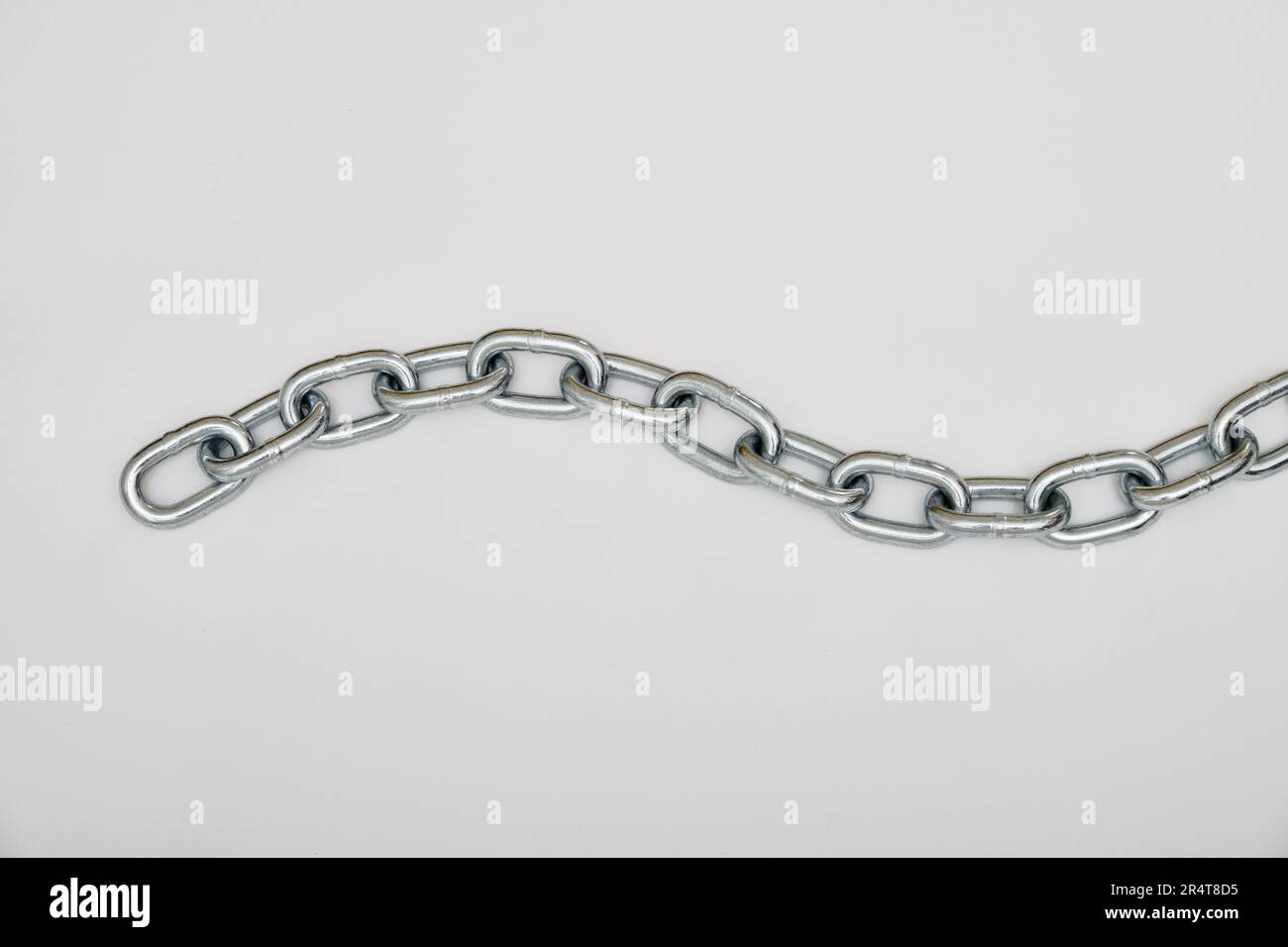 Top view of piece of strong silver metal chain placed on gray background Stock Photo