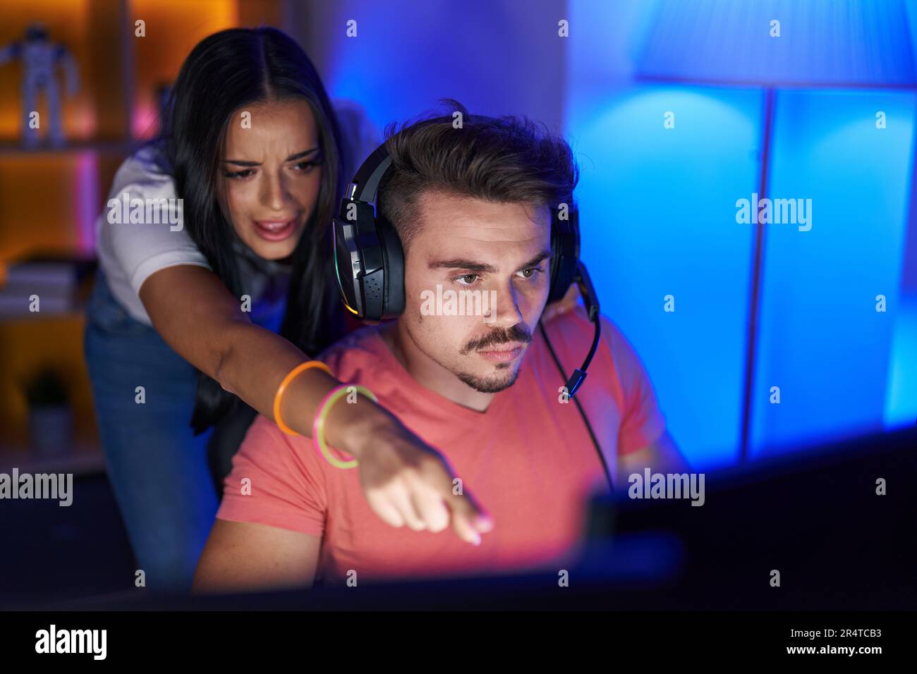 Man and woman streamers playing video game using computer at gaming ...