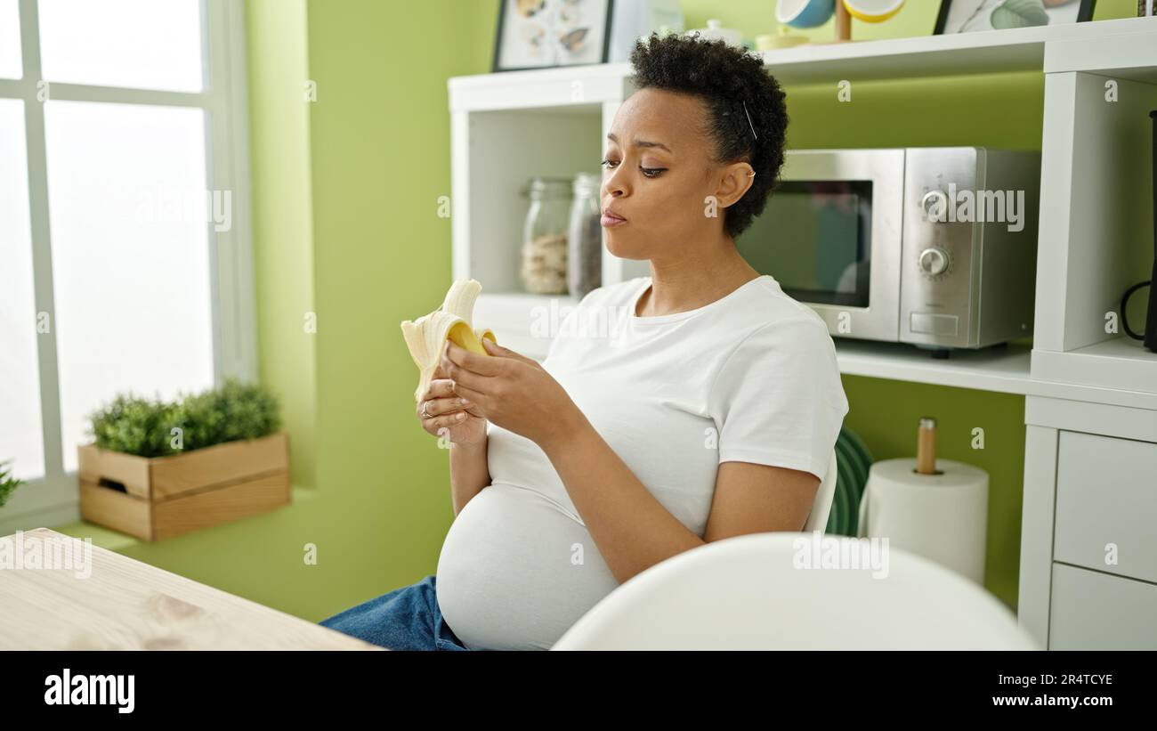 Young african woman peeling banana hi-res stock photography and images ...