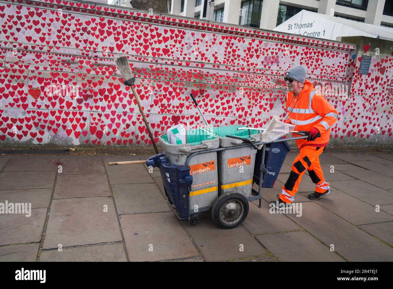 London UK. 30 May 2023 A  Lambeth council worker collects the rubbish along The national covid memorial wall  a public mural comprising thousands of red and pink hearts to commemorate the victims of the COVID-19 pandemic  in the UK. The Covid-19 Inquiry  will start on June 13  that  has been set up to examine the UK’s response to and impact of the Covid-19 pandemic, and learn lessons for the future s chaired by Baroness Heather Hallett, a former Court of Appeal judge . Credit: amer ghazzal/Alamy Live News Stock Photo