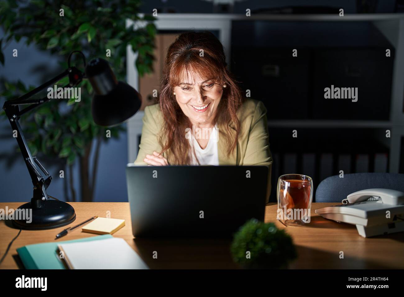 Middle age hispanic woman working using computer laptop at night happy ...