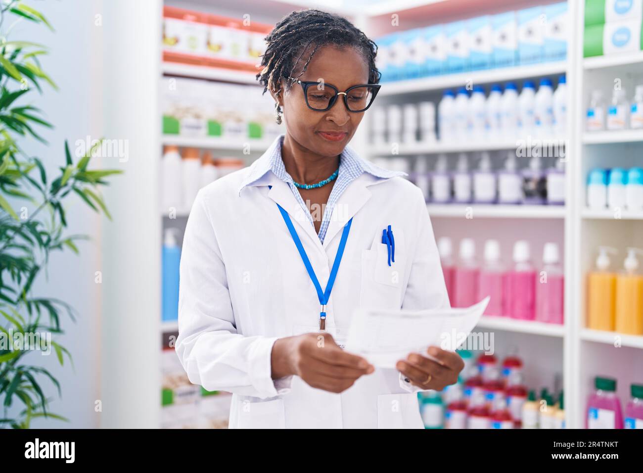 Middle Age African American Woman Pharmacist Reading Prescription At ...