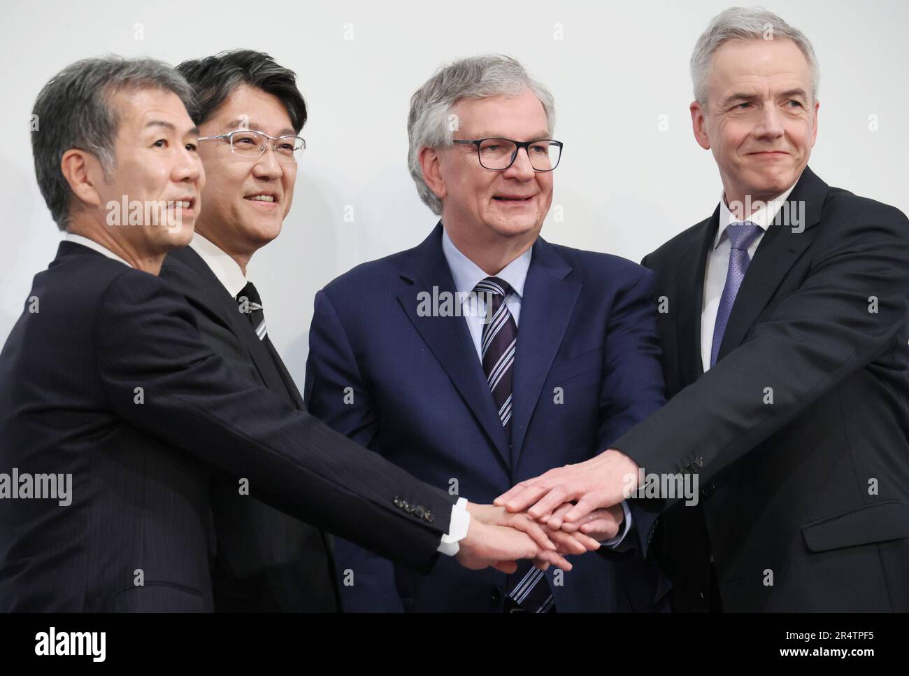May 30, 2023, Tokyo, Japan - (L-R) Japan's Hino Motors CEO Satoshi Ogiso, Toyota Motor CEO Koji Sato, Germany's Daimler Truck CEO Martin Daum and Daimler's subsidiary MFTBC (Mitsubishi Fuso) CEO Karl Depper join their hands as they announced Hino and MFTBC will merge their businesses and Toyota and Daimler Truck will form a holding company at a press conference in Tokyo on Tuesday, May 30, 2023.     (photo by Yoshio Tsunoda/AFLO) Stock Photo