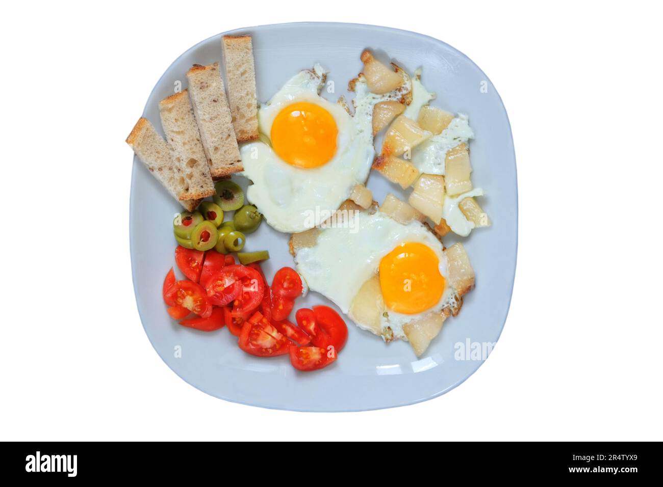 Fried eggs with lard, tomatos and green olives in a plate isolated on a white background