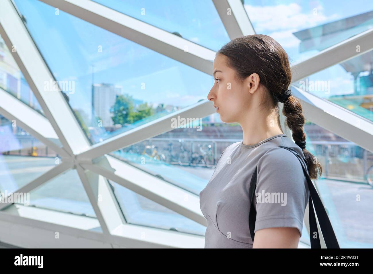 Portrait of teenage girl inside modern building, urban city background ...