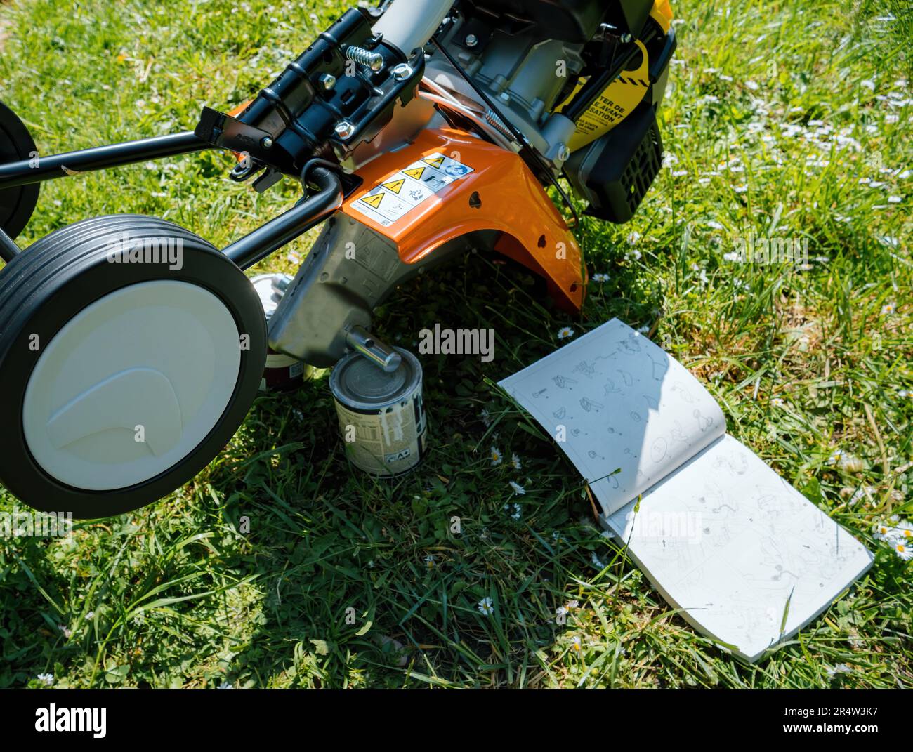 Frankfurt, Germany - May 3, 2023: A technician carefully assembles a Stihl Tiller MH 585 in a green garden, reading the manual to utilize this versati Stock Photo