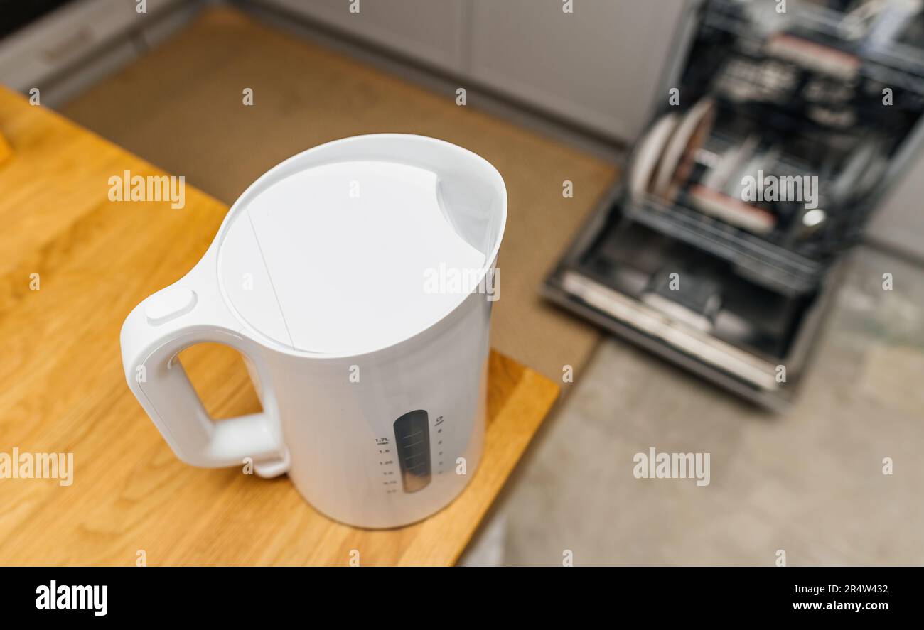 A modern kitchen with a stainless steel kettle boiling water on the