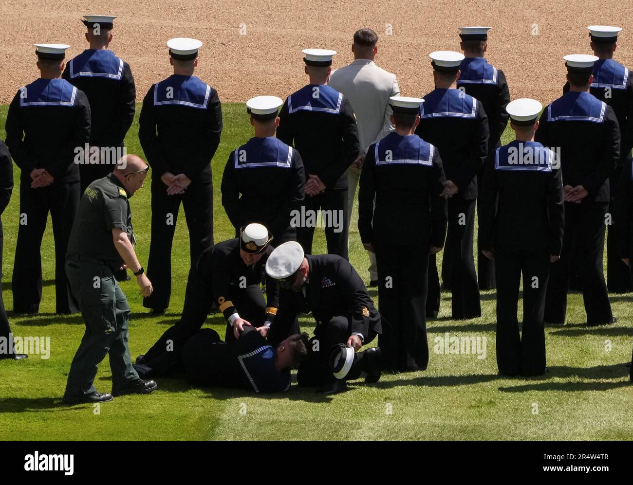 A member of Royal Navy who collapsed gets attended to during a ceremony ...