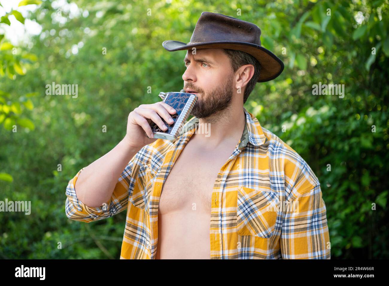 masculine cowboy drink from flask wear hat. photo of masculine cowboy