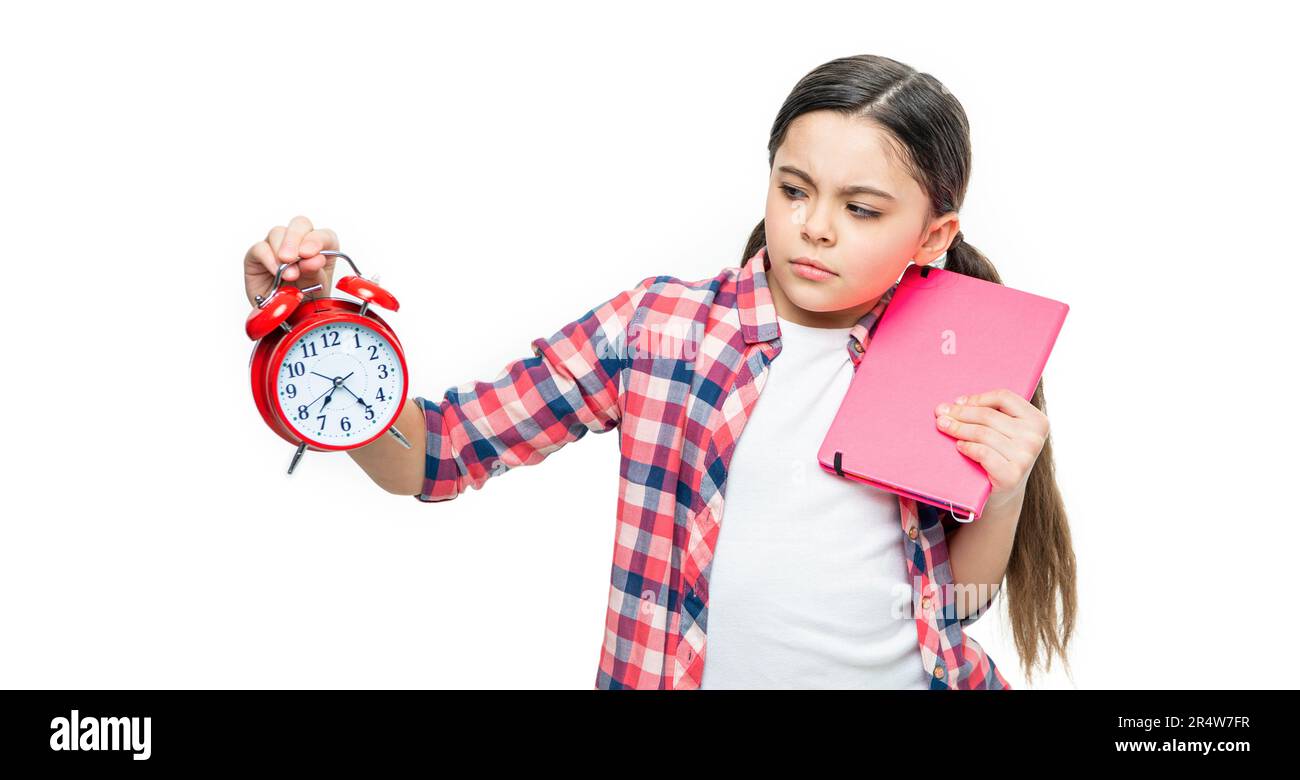 photo of unhappy school girl with alarm clock and homework. school girl
