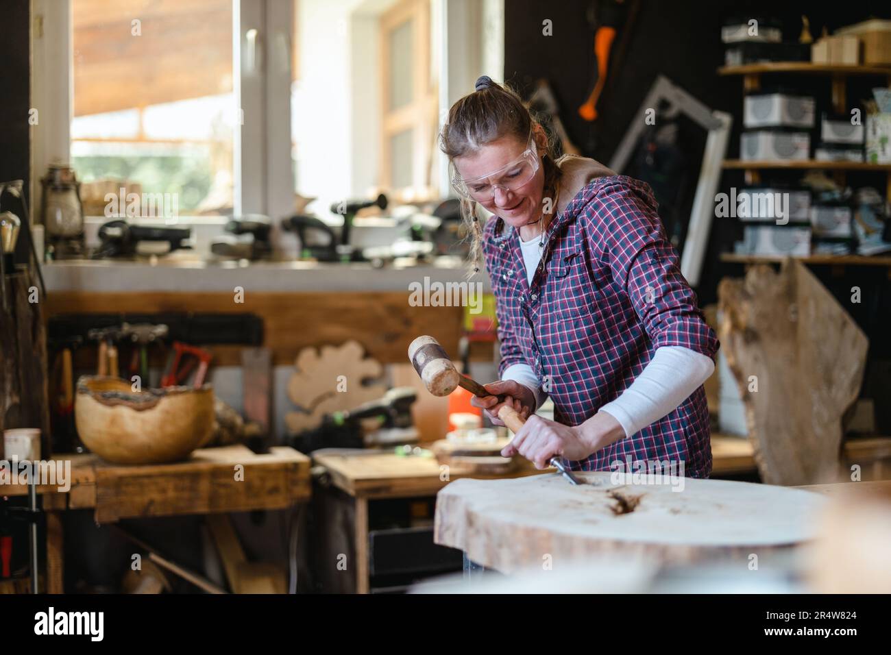 Craftswoman working with wood in carpentry workshop Stock Photo
