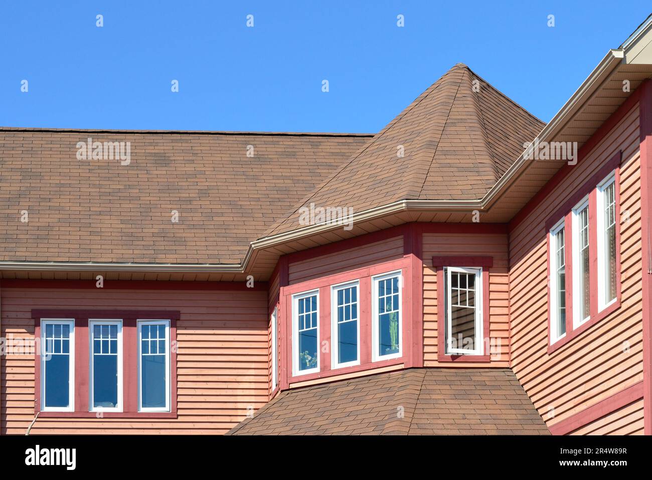A large turret with multiple long narrow windows, white and pink in color. The roof has brown