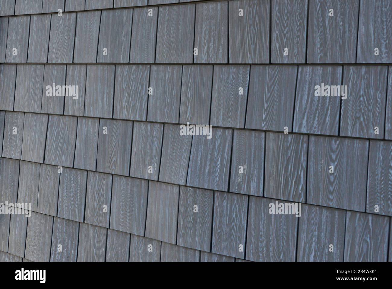 Natural grey cedar shake siding worn and textured on an exterior wall