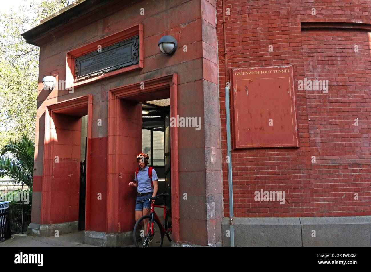 Cyclist emerging from the north entrance of the Greenwich Foot Tunnel on the Isle of Dogs, London, a historic pedestrian crossing beneath the Thames Stock Photo