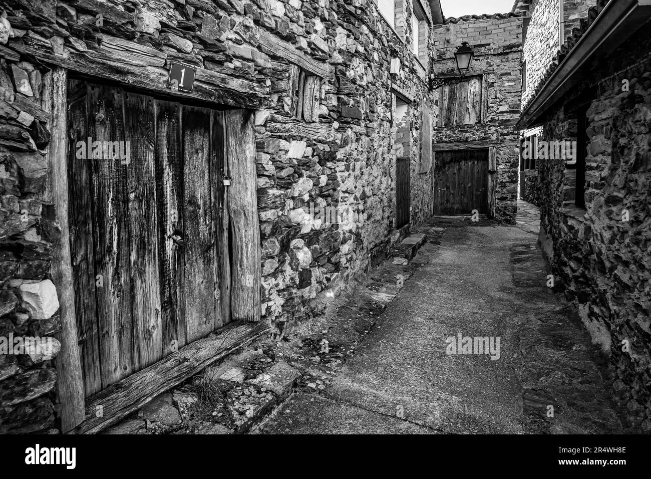 Old stone houses forming a narrow alley in an old village of Madrid, Puebla de la Sierra. Stock Photo