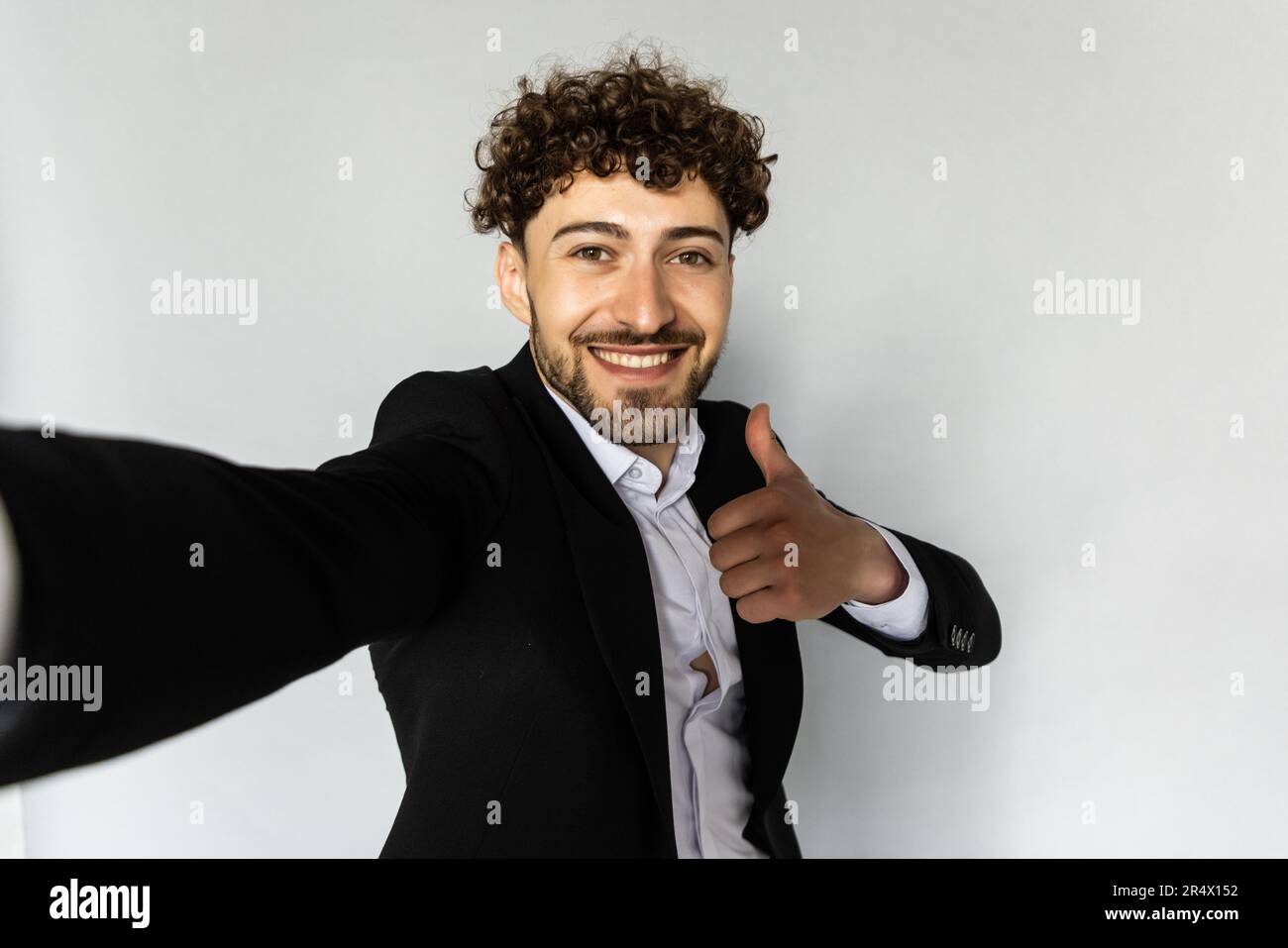 Image of successful man 30s in business suit gesturing hand aside while taking selfie photo isolated over gray background Stock Photo