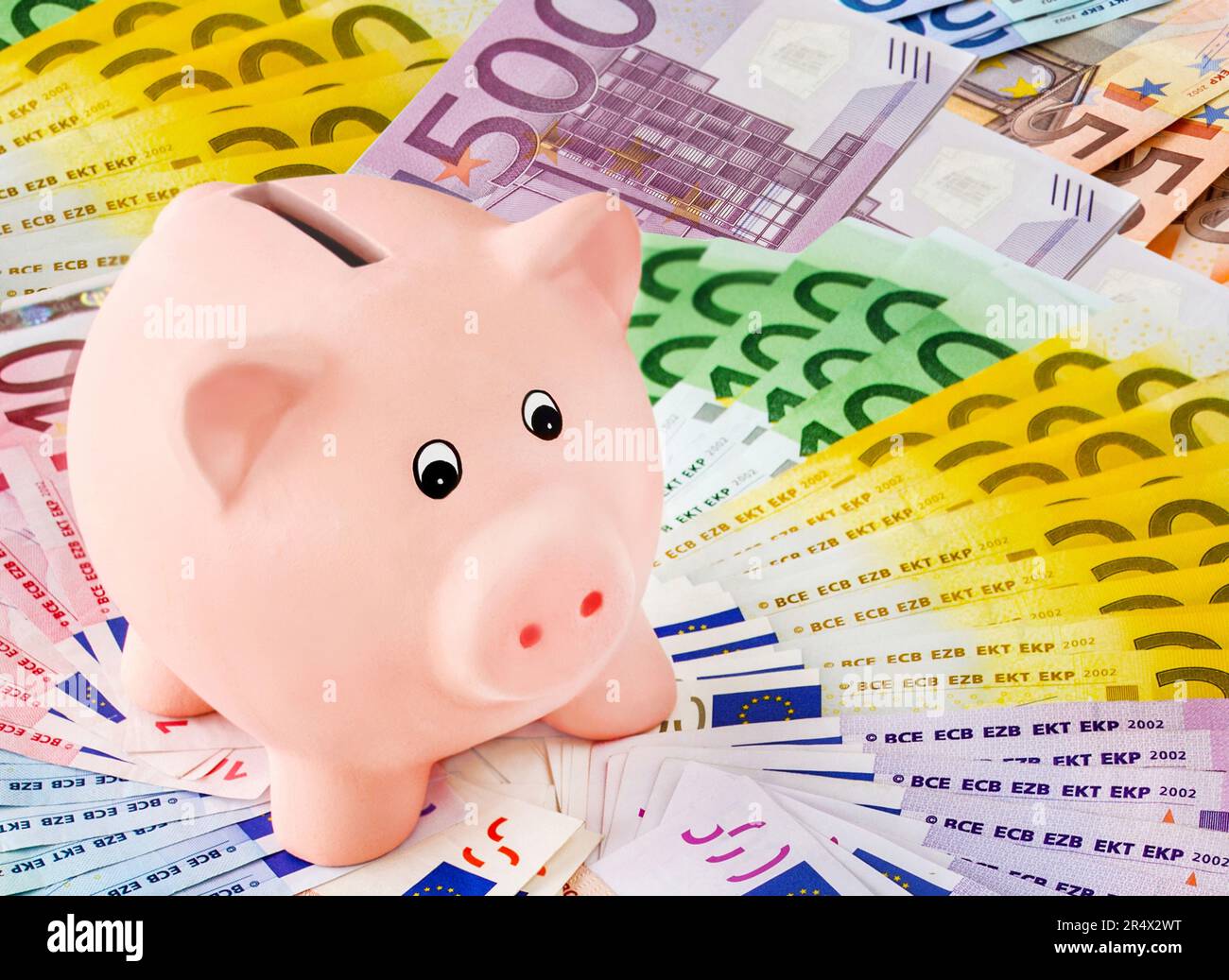 Finances and pink Piggy Bank with Euro banknotes Stock Photo