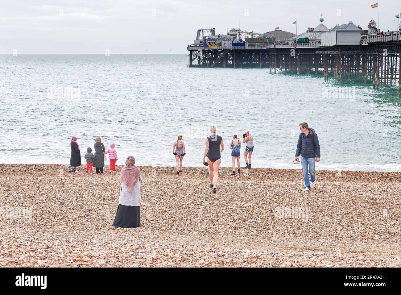 A man looks at a woman in a bathing suit about to join other women on ...
