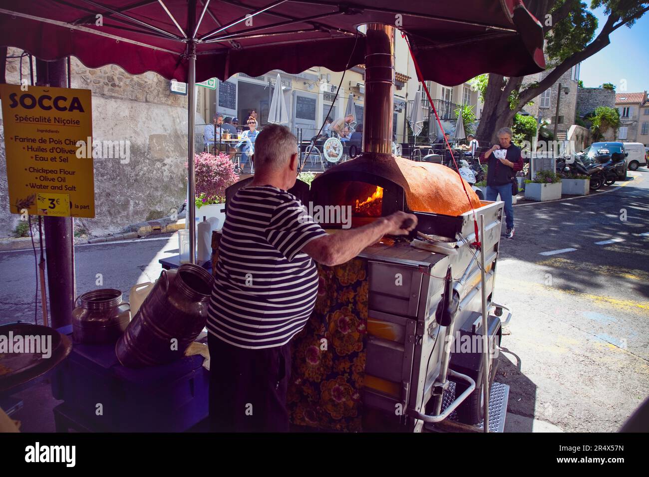 France, Provence-Alps, Cote d'Azur, Antibes, Cooking Socca an nicoise chickpea pancake Provencal food market. Stock Photo
