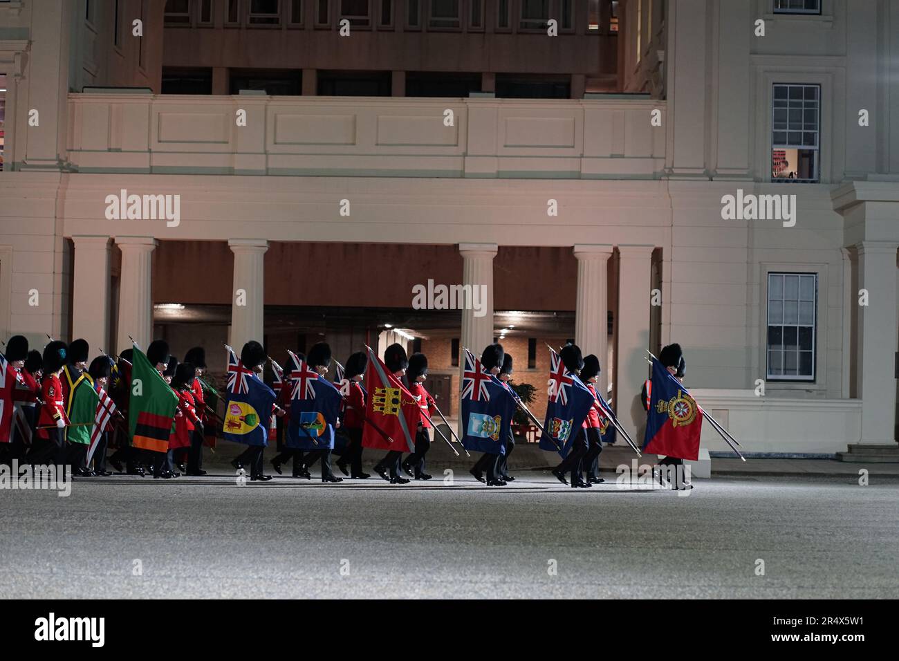 Soldiers of the Guards Division march with flags of Commonwealth nations during night rehearsals prior to the coronation of King Charles III. Stock Photo