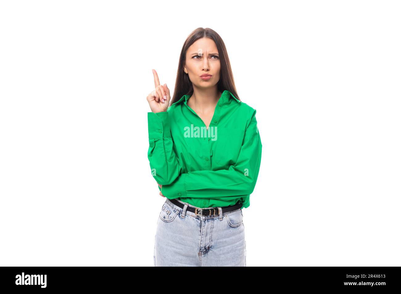portrait of a smart pensive slim cute brown-eyed brunette woman dressed in a green shirt smiling on a white background with copy space Stock Photo