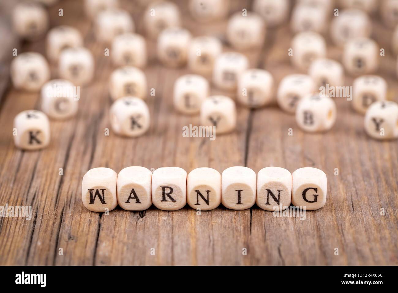 Warning word from wooden blocks with letters, alphabetical list with