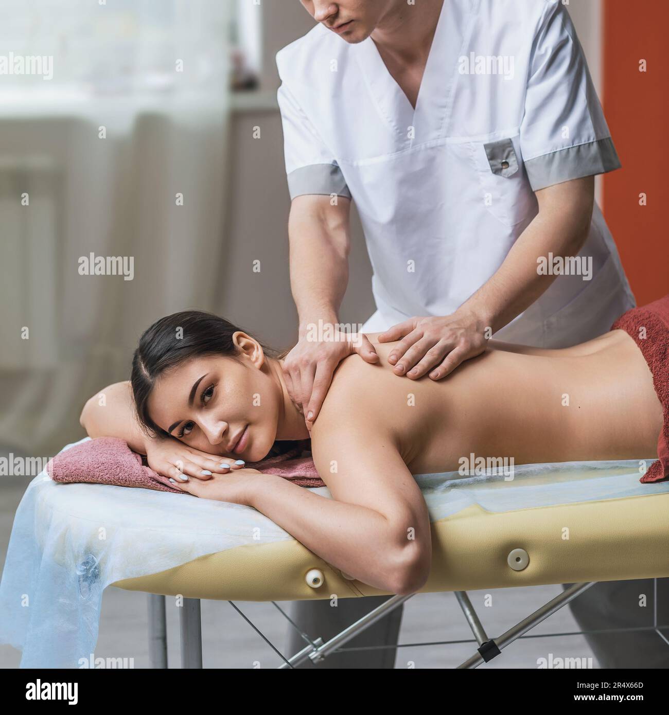 https://c8.alamy.com/comp/2R4X66D/the-masseur-conducts-a-therapy-session-for-a-client-massages-the-back-and-cervical-region-of-a-young-brunette-girl-2R4X66D.jpg