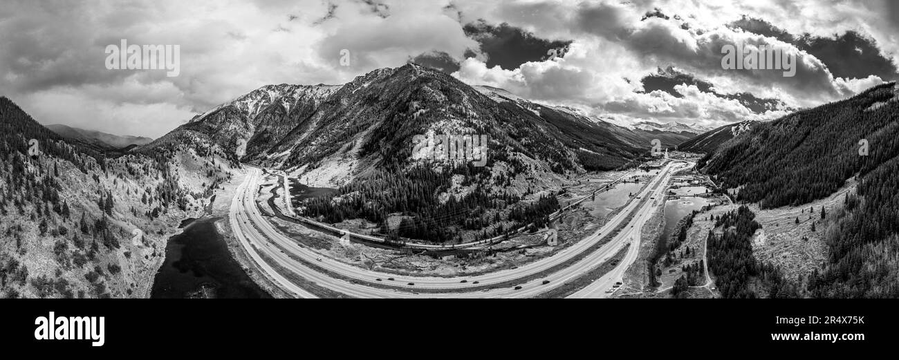 Highway Interstate 70 curves through a mountainous landscape under a cloudy sky in Colorado, USA; United States of America Stock Photo