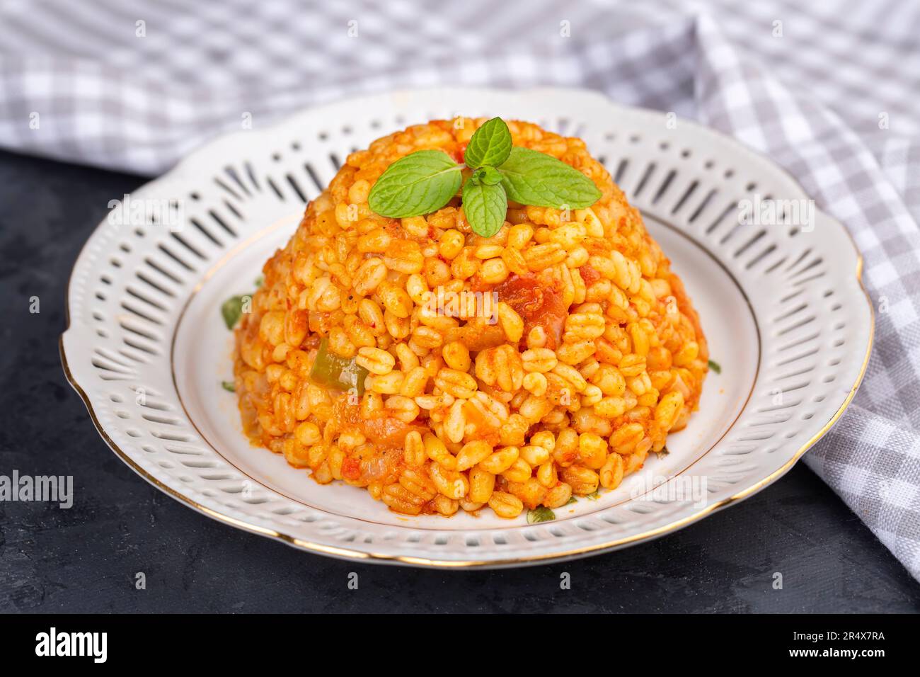 Traditional turkish bulgur pilaf with tomato sause in plate (Turkish