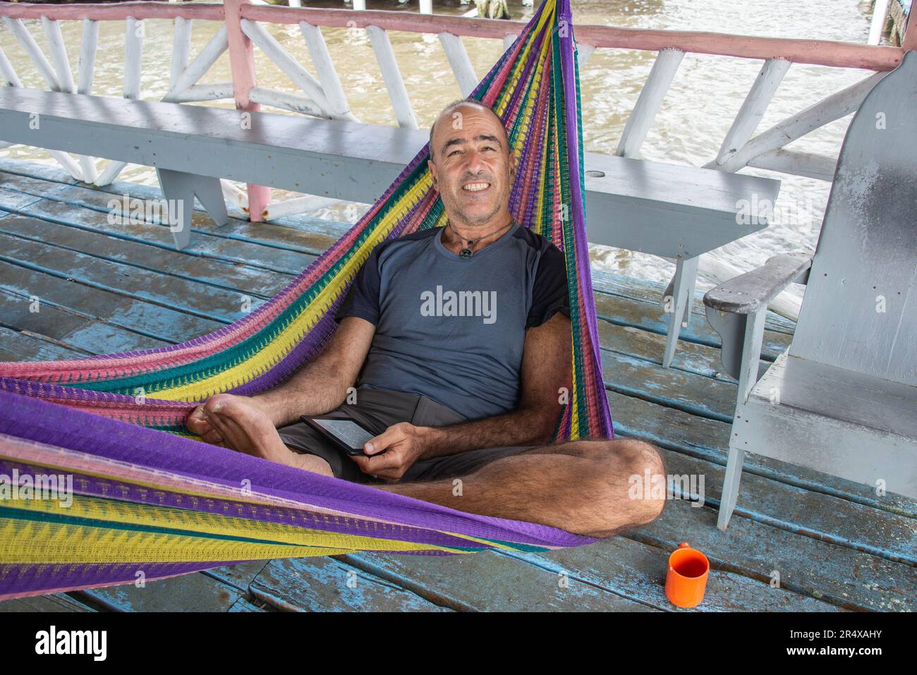 Tourist enjoying a hammock in the Garifuna community of Livingston, Guatemala Stock Photo