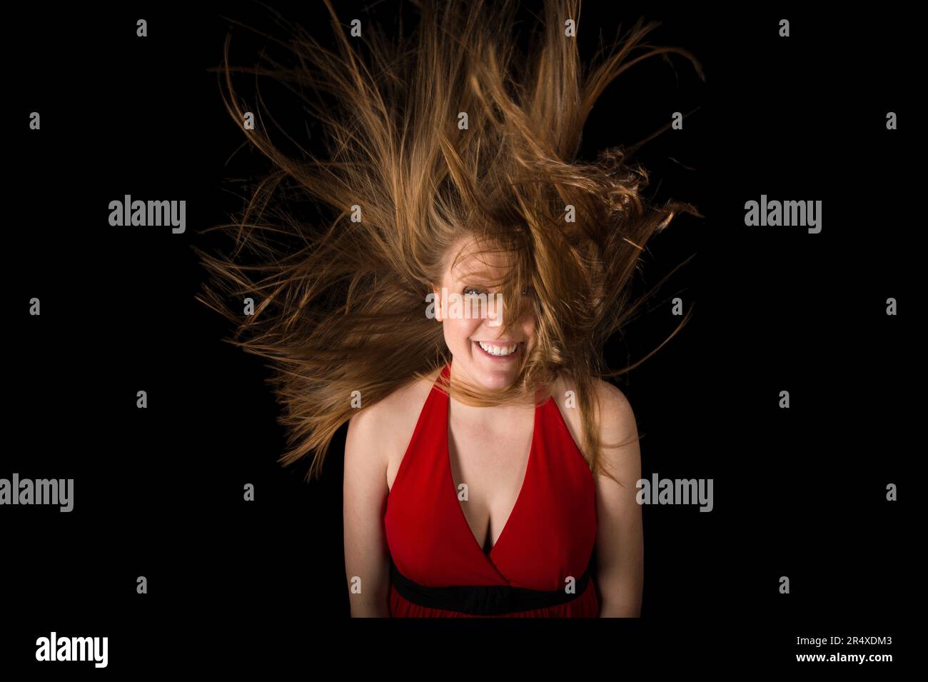 Young woman's hair flies dramatically up around her head; Lincoln, Nebraska, United States of America Stock Photo