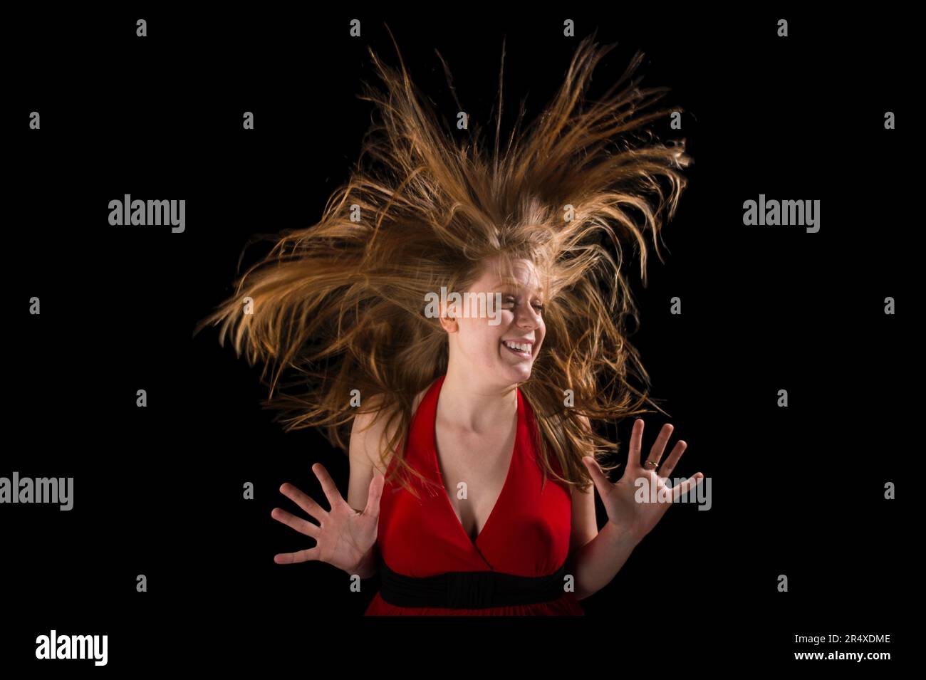 Young woman's hair flies dramatically up around her head; Lincoln, Nebraska, United States of America Stock Photo
