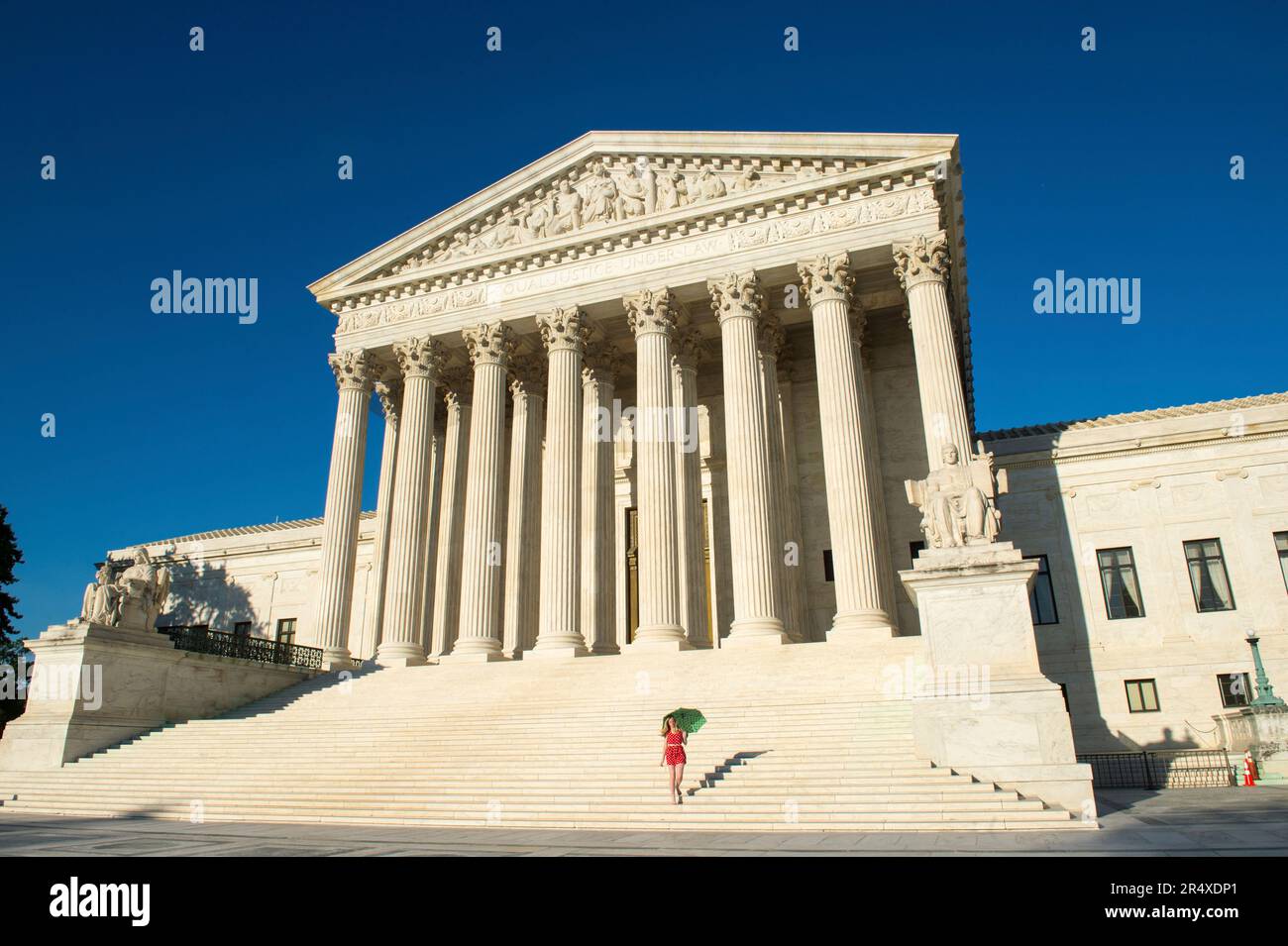 Woman with umbrella in vibrant color views walks up the steps of the U.S. Supreme Court in Washington, DC, USA Stock Photo