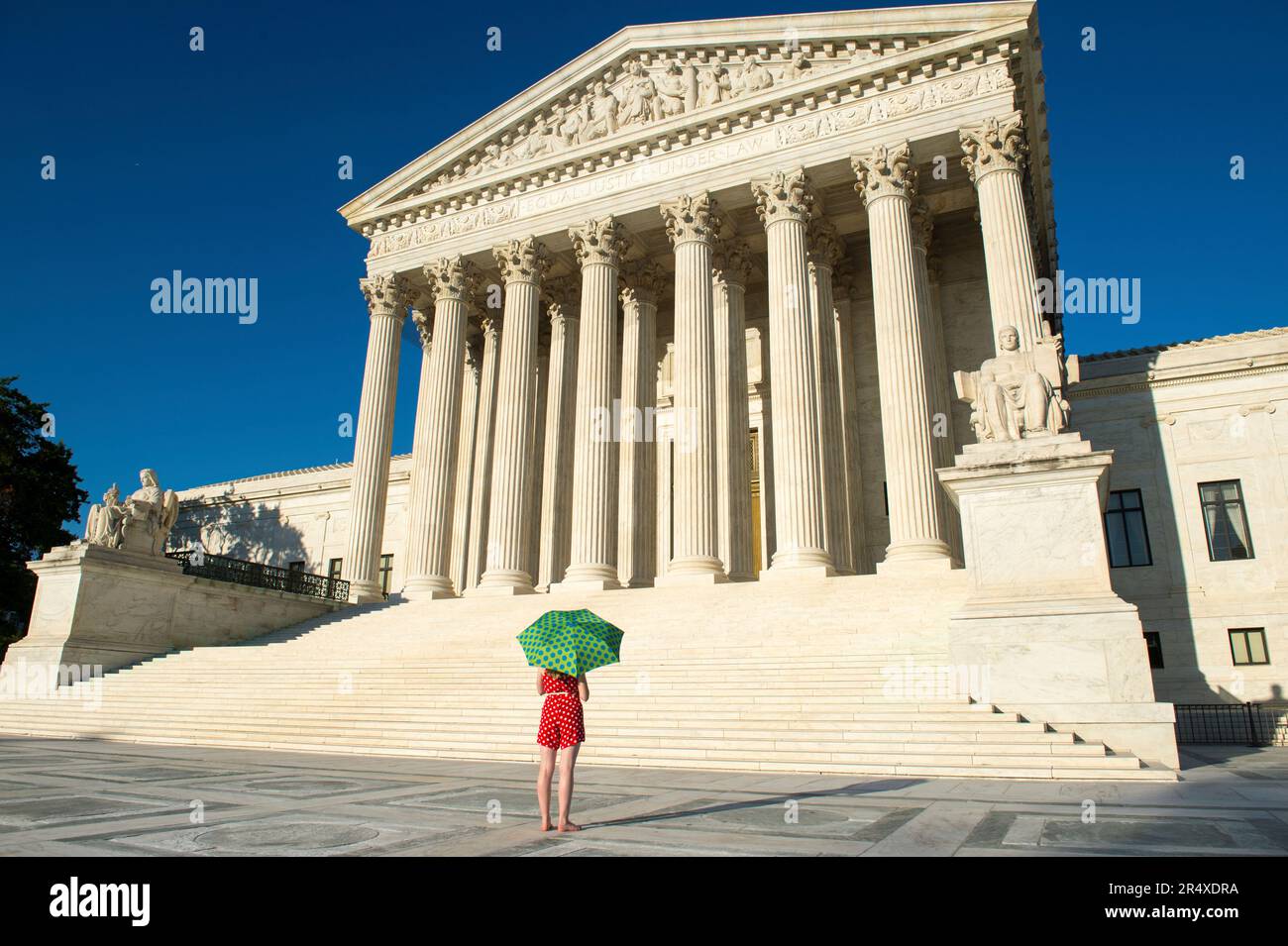 Woman with umbrella in vibrant color views the U.S. Supreme Court in Washington, DC, USA; Washington, District of Columbia, United States of America Stock Photo