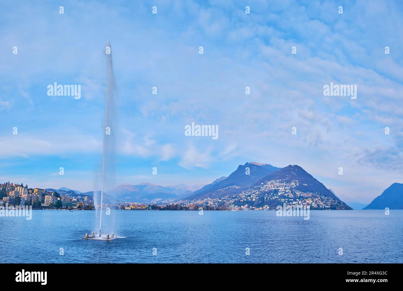 Lake Lugano with Getto d'Acqua fountain (Water Jet on the bay of Lugano, Water Jet of Paradiso) and Monte Bre in background, Lugano, Switzerland Stock Photo