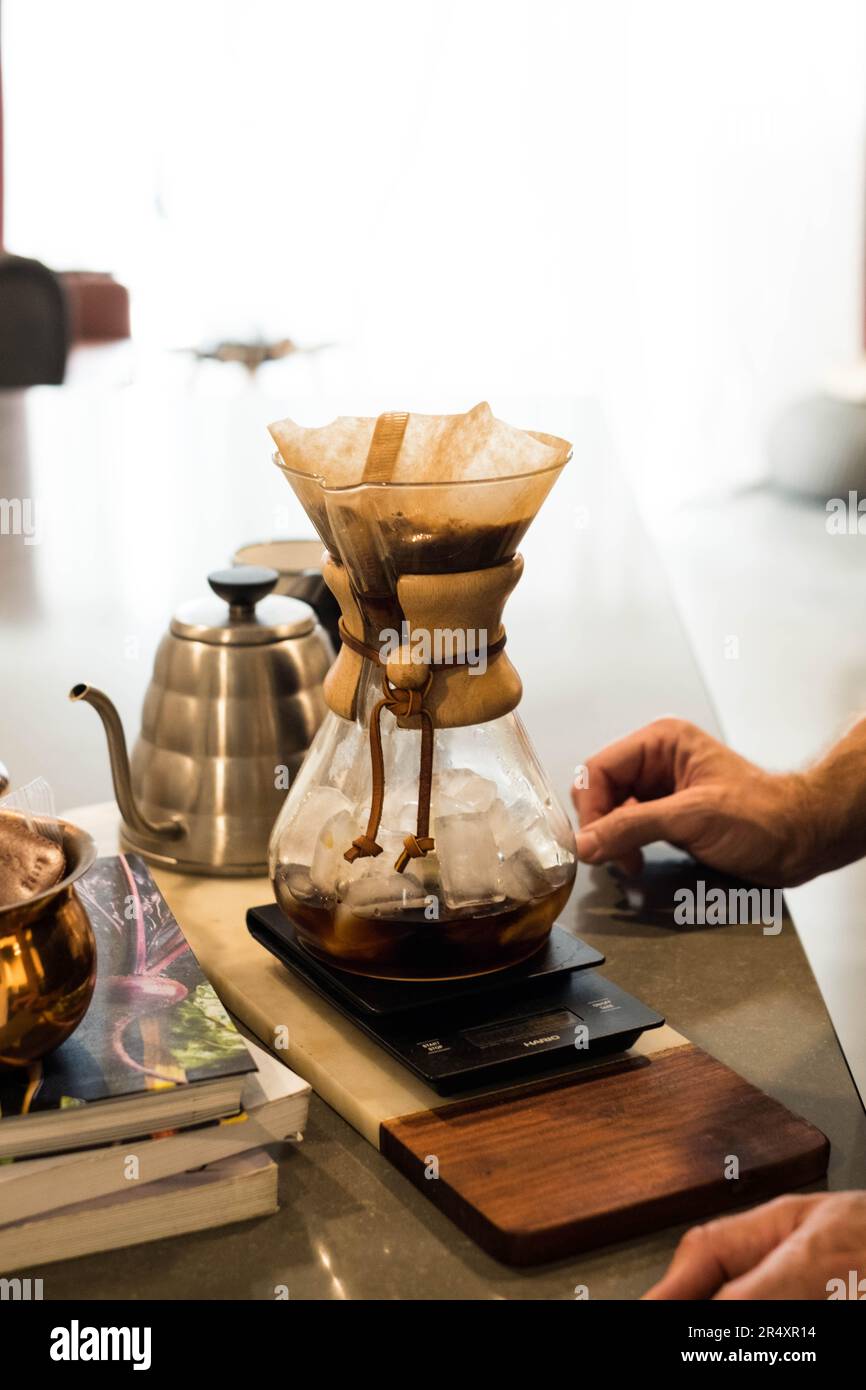 Hands making pour over iced coffee in kitchen Stock Photo Alamy