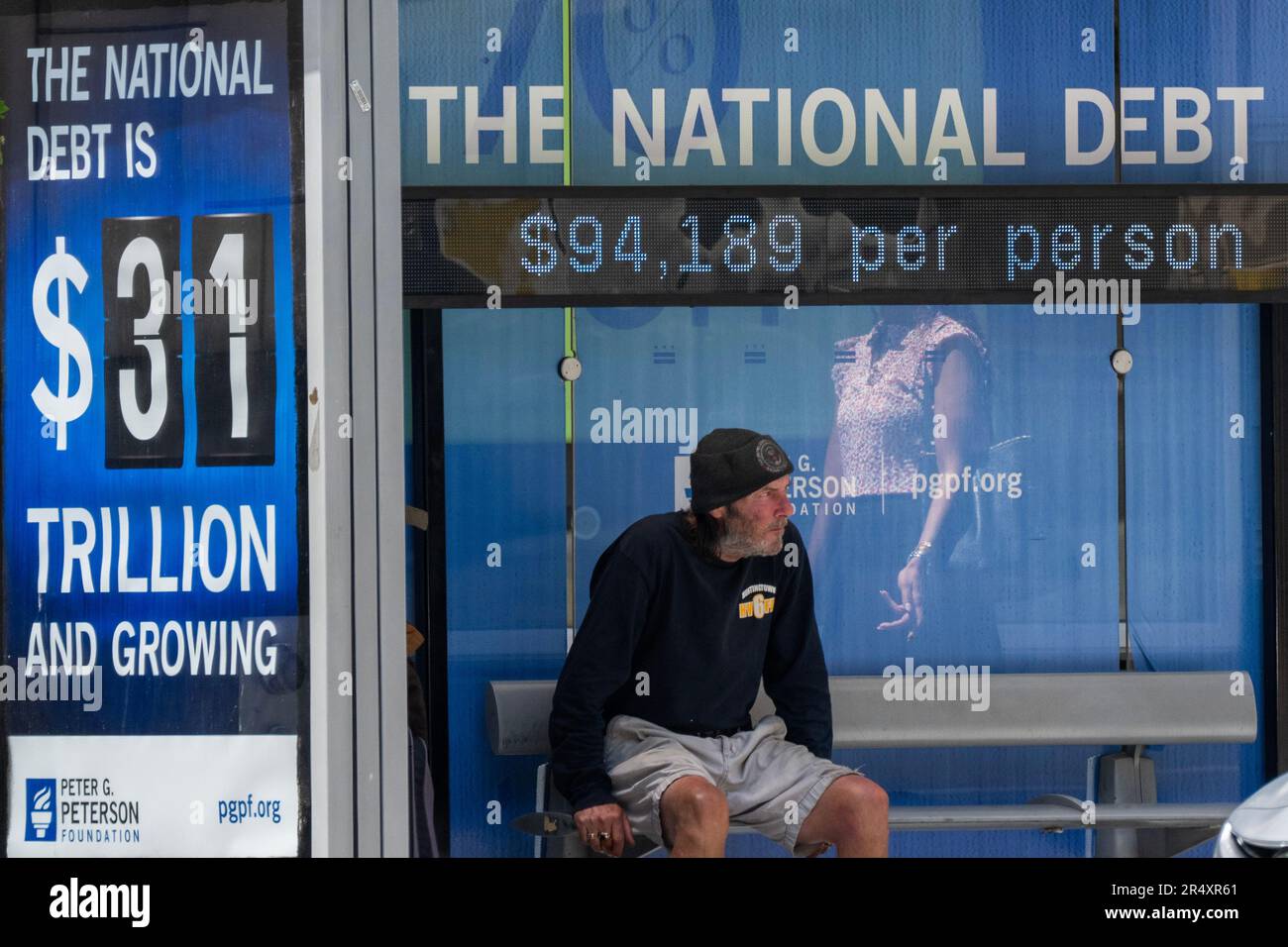 Washington, United States. 30th May, 2023. A man waits for a bus underneath a sign that keeps track of the U.S. debt, now at $31 trillion or $94,189 per person, in downtown Washington, DC on Tuesday, May 30, 2023. The House will vote tomorrow on the debt ceiling agreement between President Joe Biden and Speaker of the House Kevin McCarthy. Photo by Pat Benic/UPI Credit: UPI/Alamy Live News Stock Photo