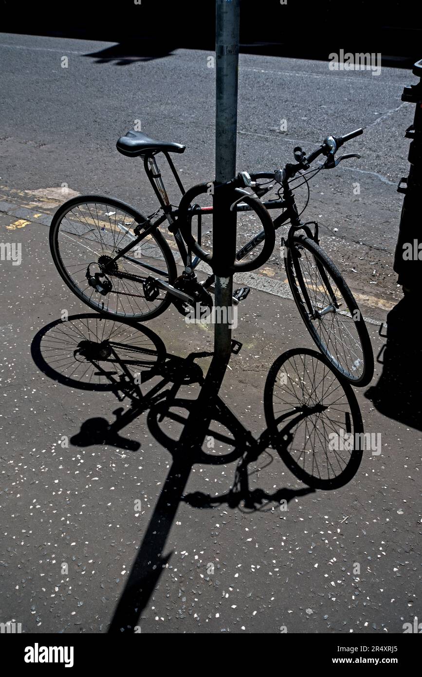 Bicycle casting its shadow onto the pavement in Edinburgh, Scotland, UK. Stock Photo