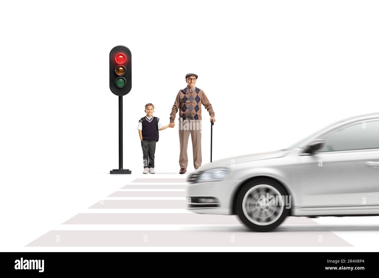 Elderly man and a schoolboy waiting to cross street at traffic lights ...