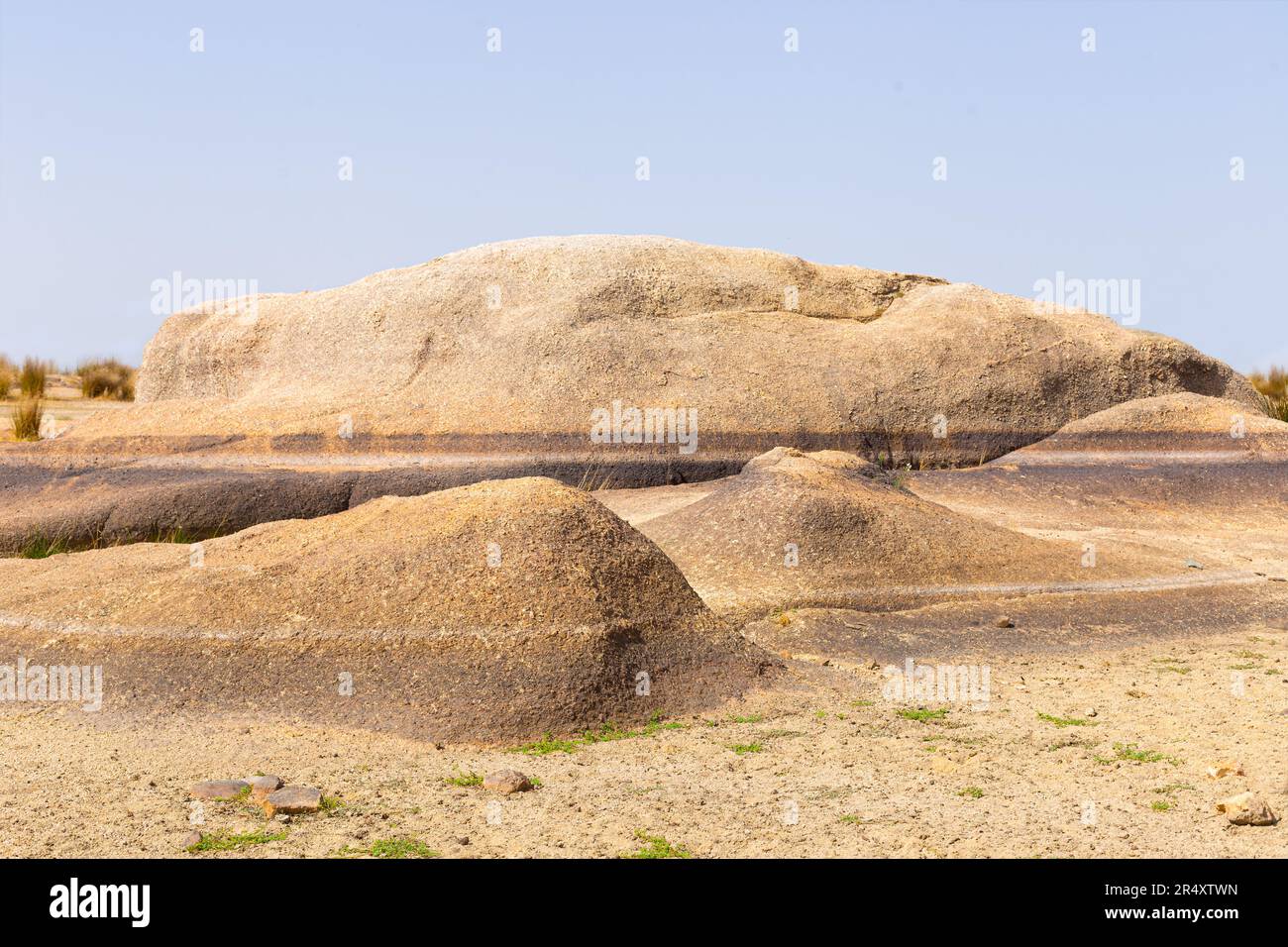 Rocks from dry lake with water level markings. You can see where water came. Sky is blue. Stock Photo