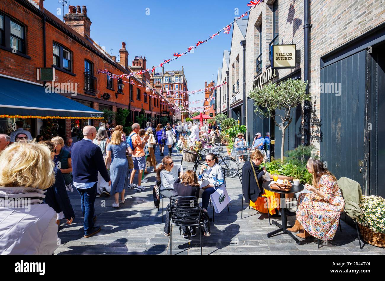 Vibrant roadside cafe culture and restaurants in Symons Street in the Sloane Square area of London SW3 on a sunny day during the Chelsea Flower Show Stock Photo