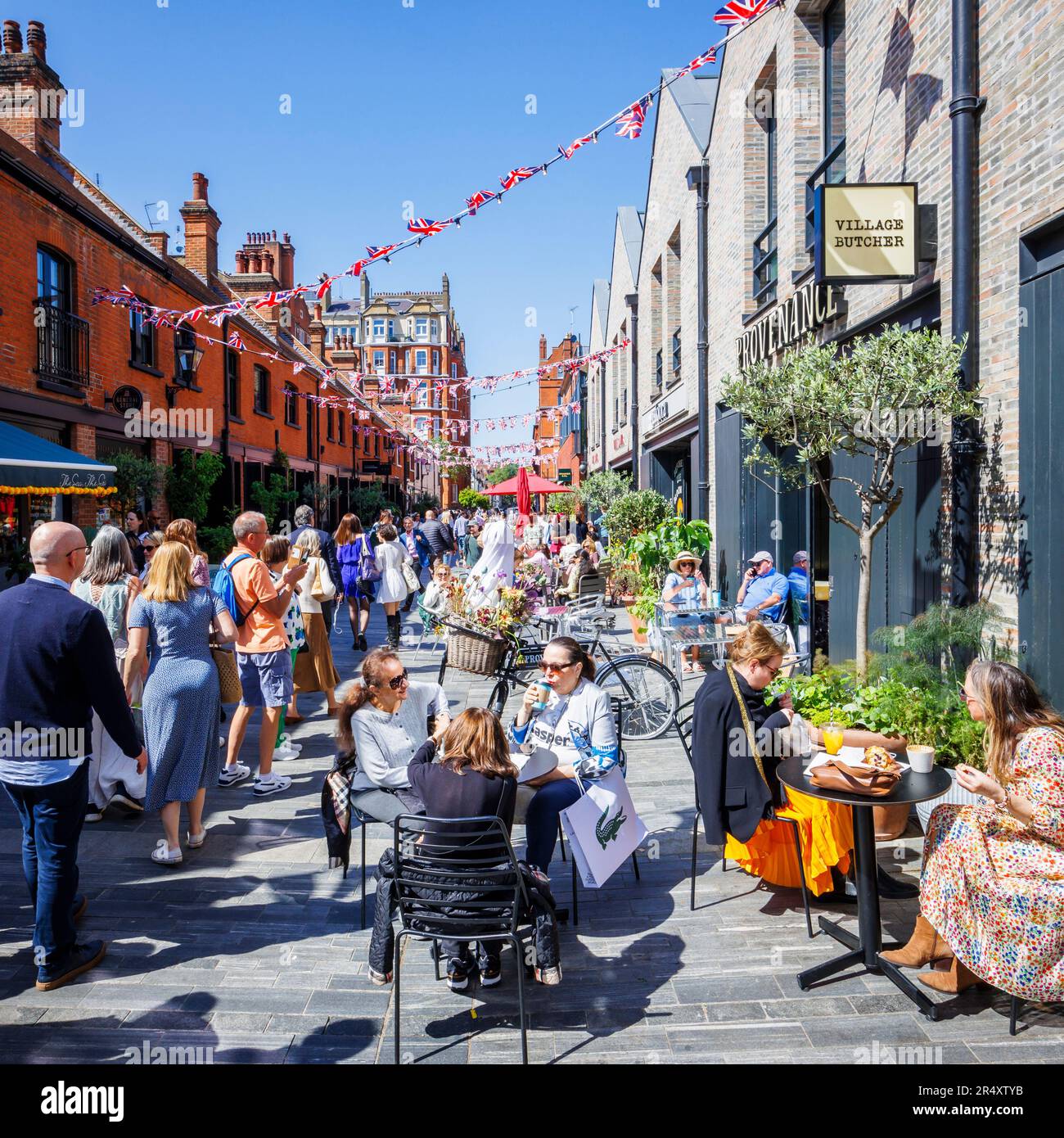 Vibrant roadside cafe culture and restaurants in Symons Street in the Sloane Square area of London SW3 on a sunny day during the Chelsea Flower Show Stock Photo