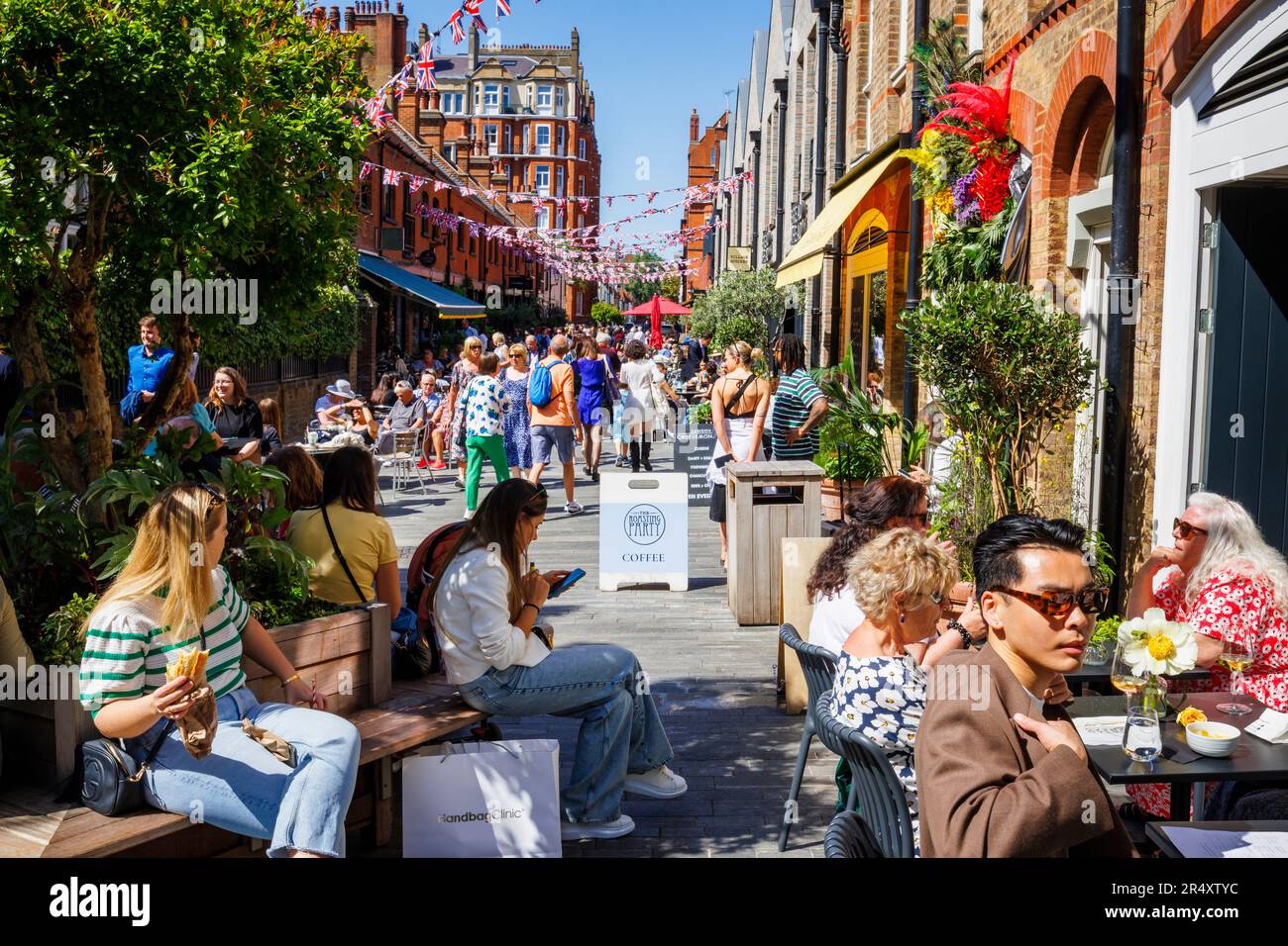 Vibrant roadside cafe culture and restaurants in Symons Street in the Sloane Square area of London SW3 on a sunny day during the Chelsea Flower Show Stock Photo