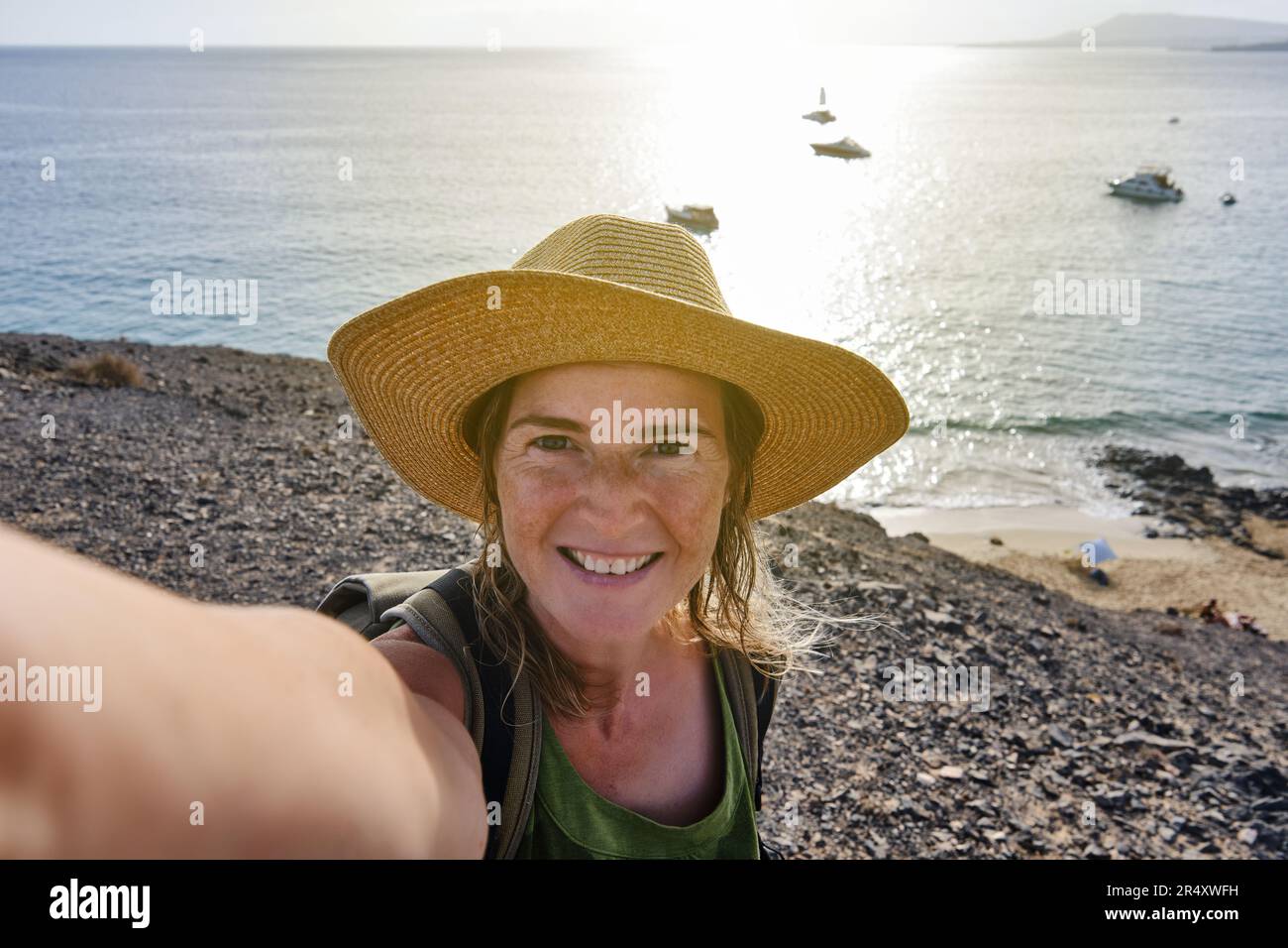A Tourist taking a selfie from a cliff on the coast during his summer ...